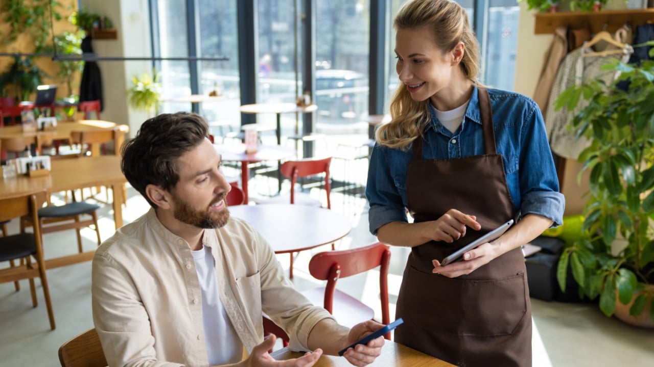 Waiter entering order on tablet at restaurant
