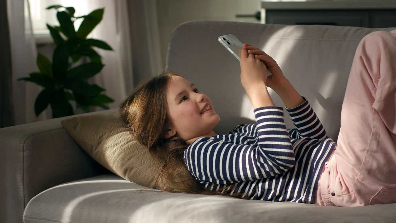 Little girl holding mobile phone smartphone communication connection video call talking chatting device technology online friendship child female kid network browse meeting conference home cellphone