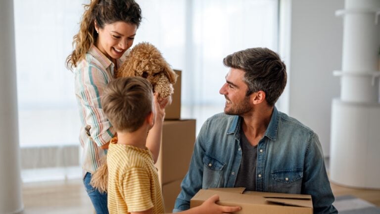 Happy family with cardboard boxes in new house at moving day. Mortgage, family,