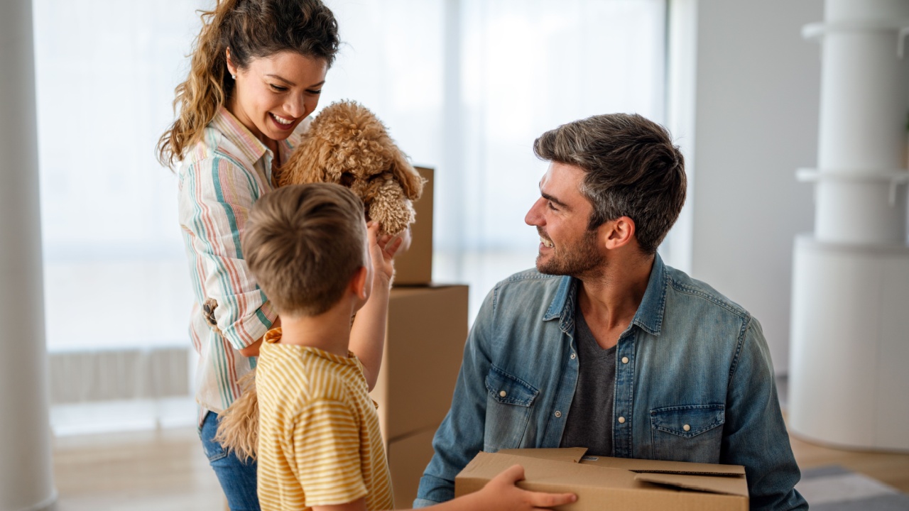 Happy family with cardboard boxes in new house at moving day. Mortgage, family,