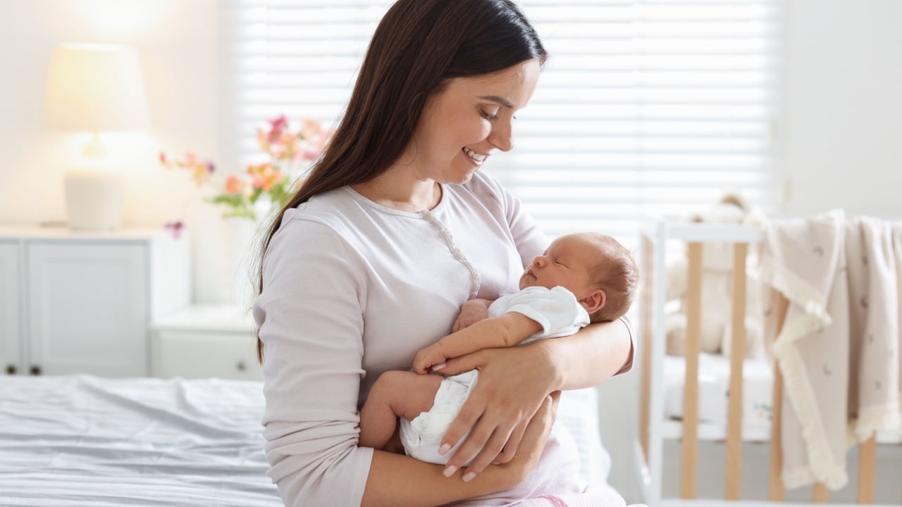 Mom with her newborn baby on bed at home