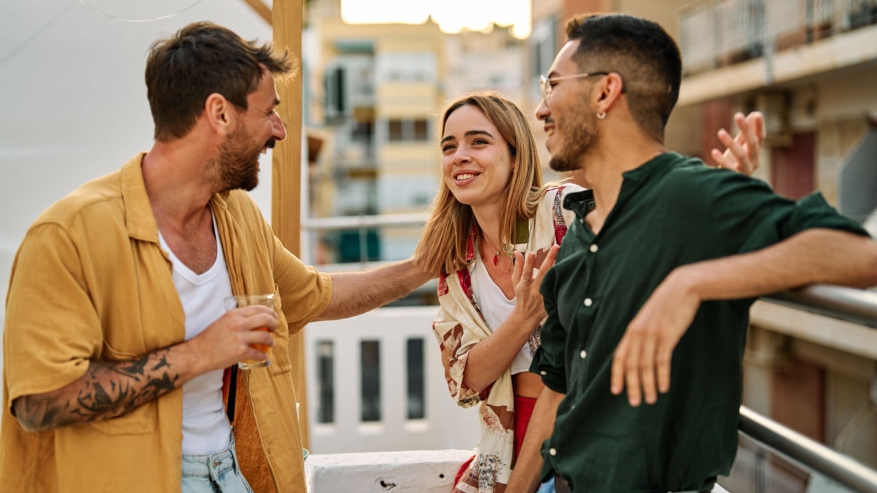 Happy young people having fun during a rooftop party during a summer holiday.