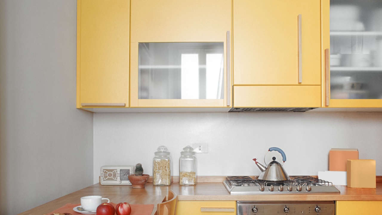 pale yellow interior view of a modern kitchen in foreground the cooker