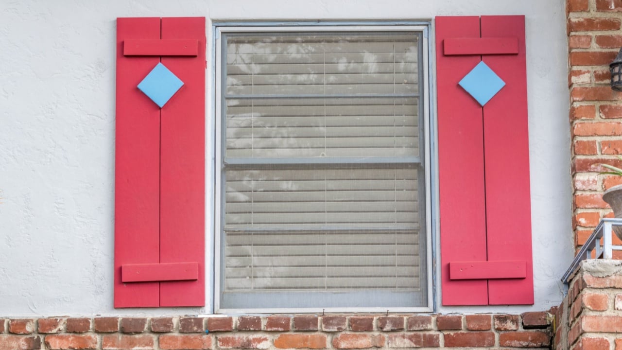 simple sash window with red faux shutters