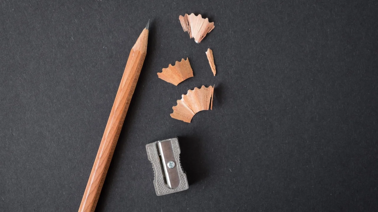 Wood texture pencil with sharpening shavings on black craft paper background