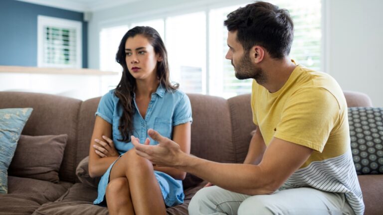 Couple arguing with each other in living room at home