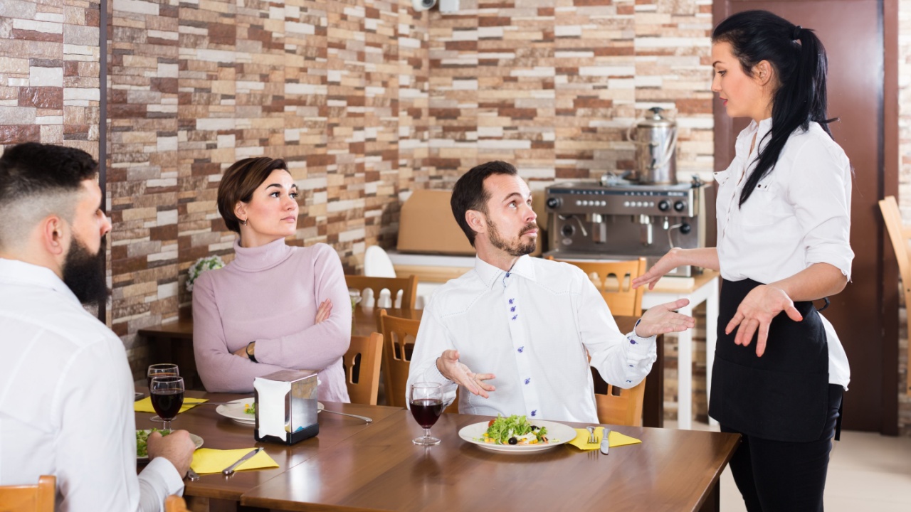 irritated cafe visitors sitting at table and showing service discontent 