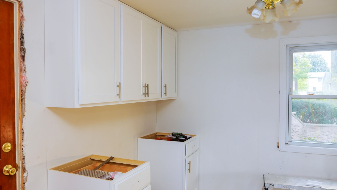 Installing new induction hob in modern kitchen Installation of kitchen cabinet. white color