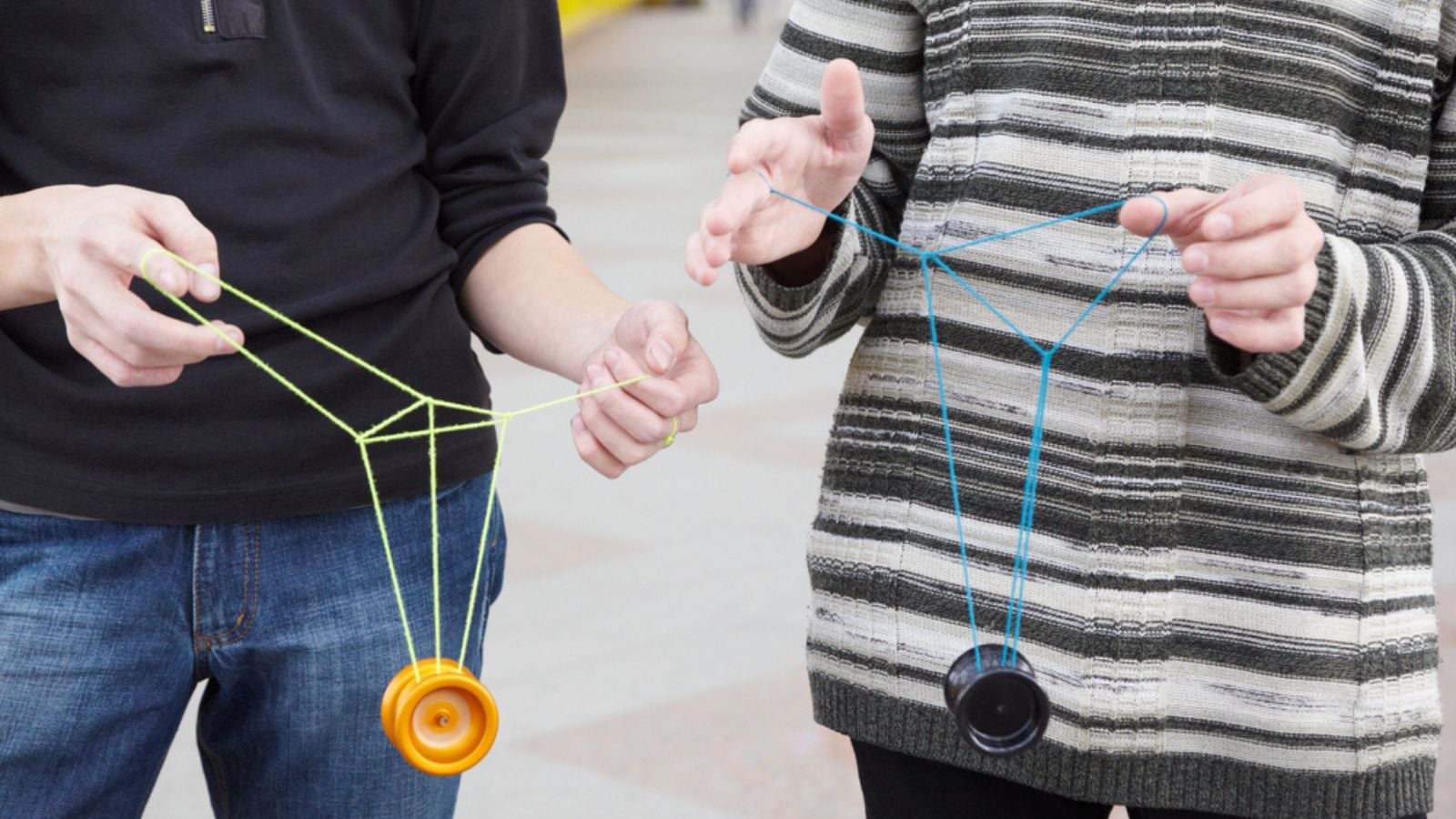 Two teens with yo-yo toys in their hands, focus on clothes