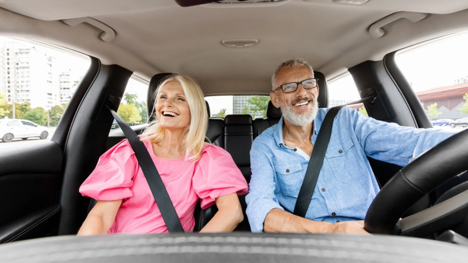 happy excited retired old couple driving car on roadtrip