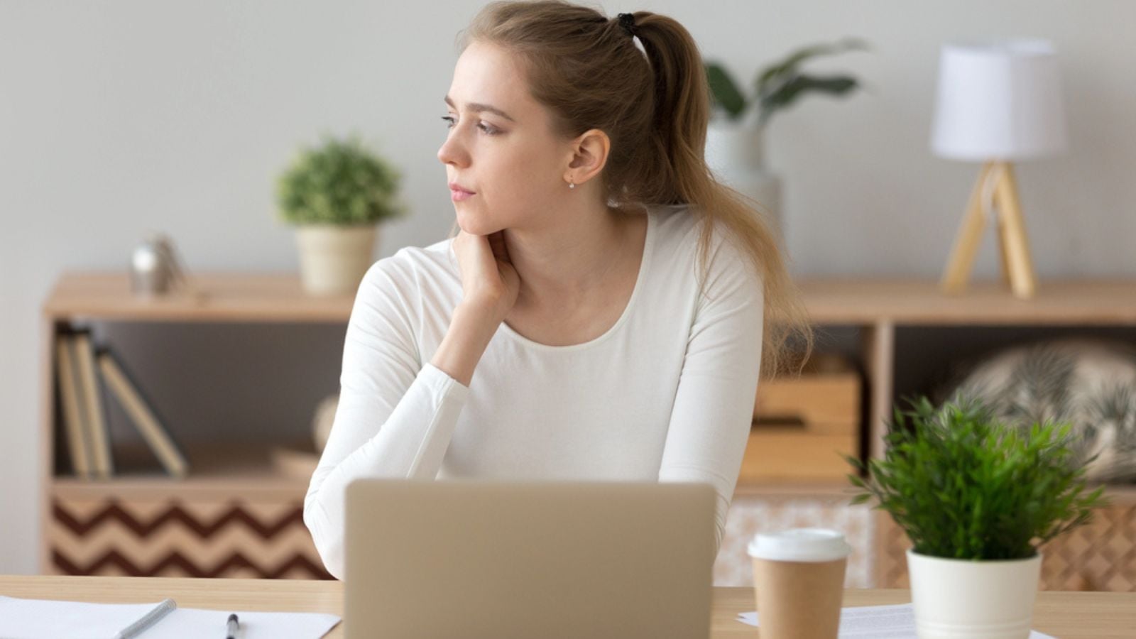 serious thinking woman looking away searching new ideas working on laptop