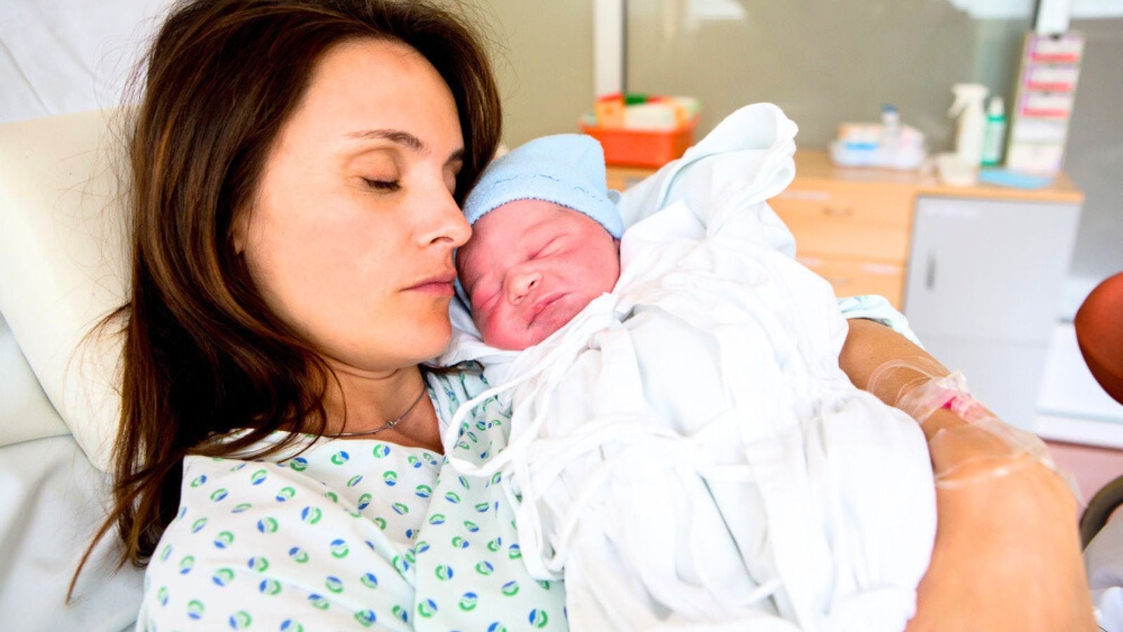 Happy mom, having her baby skin to skin first seconds after birth