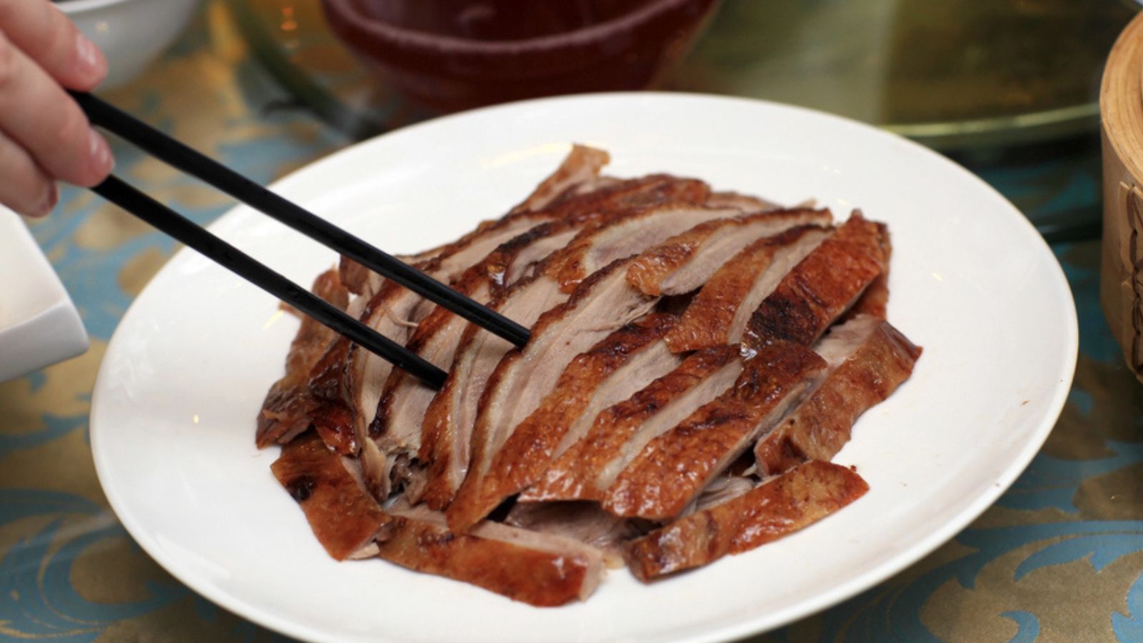 Person takes slice of peking duck