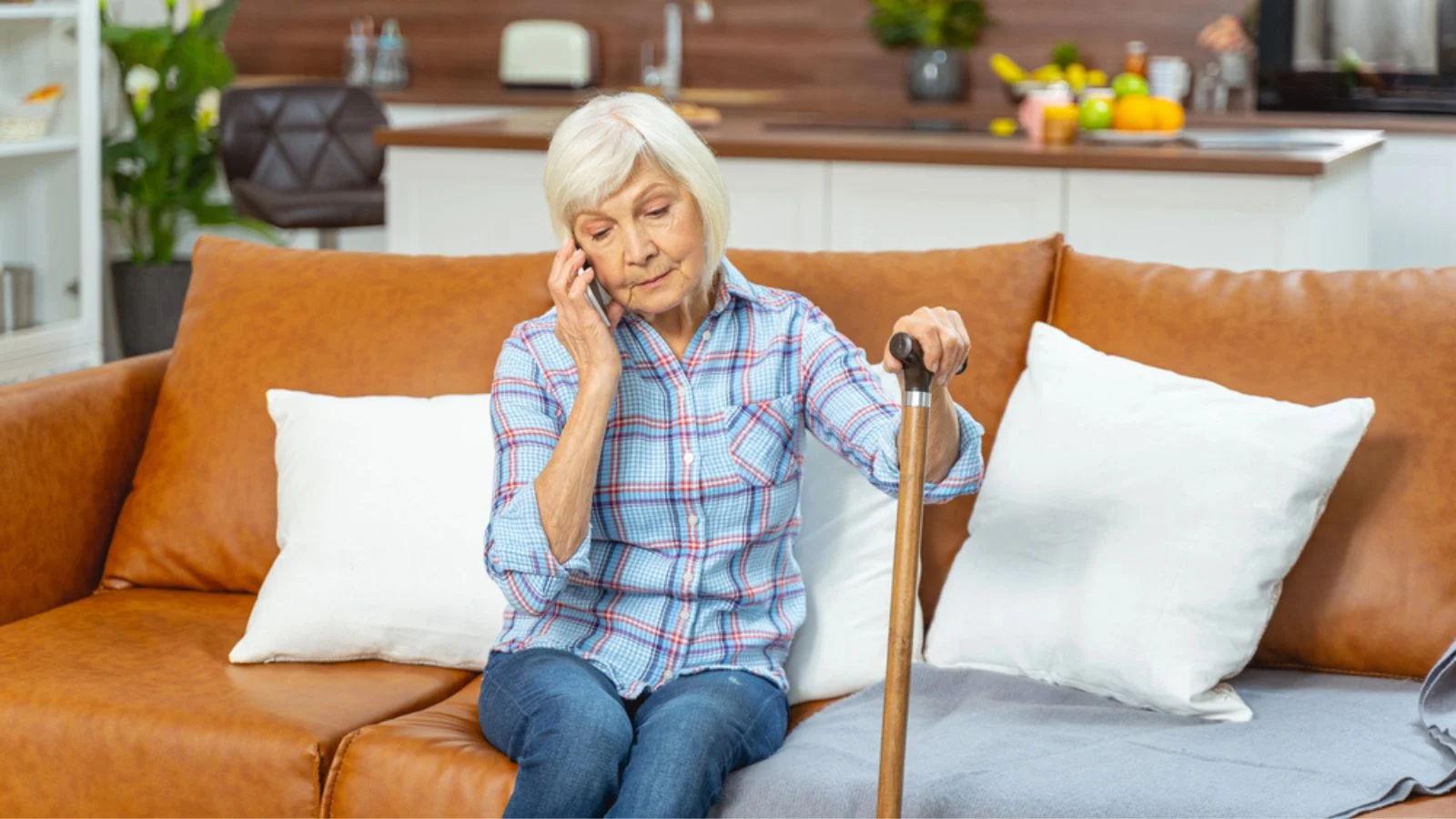 Sad senior housewife making a phone call