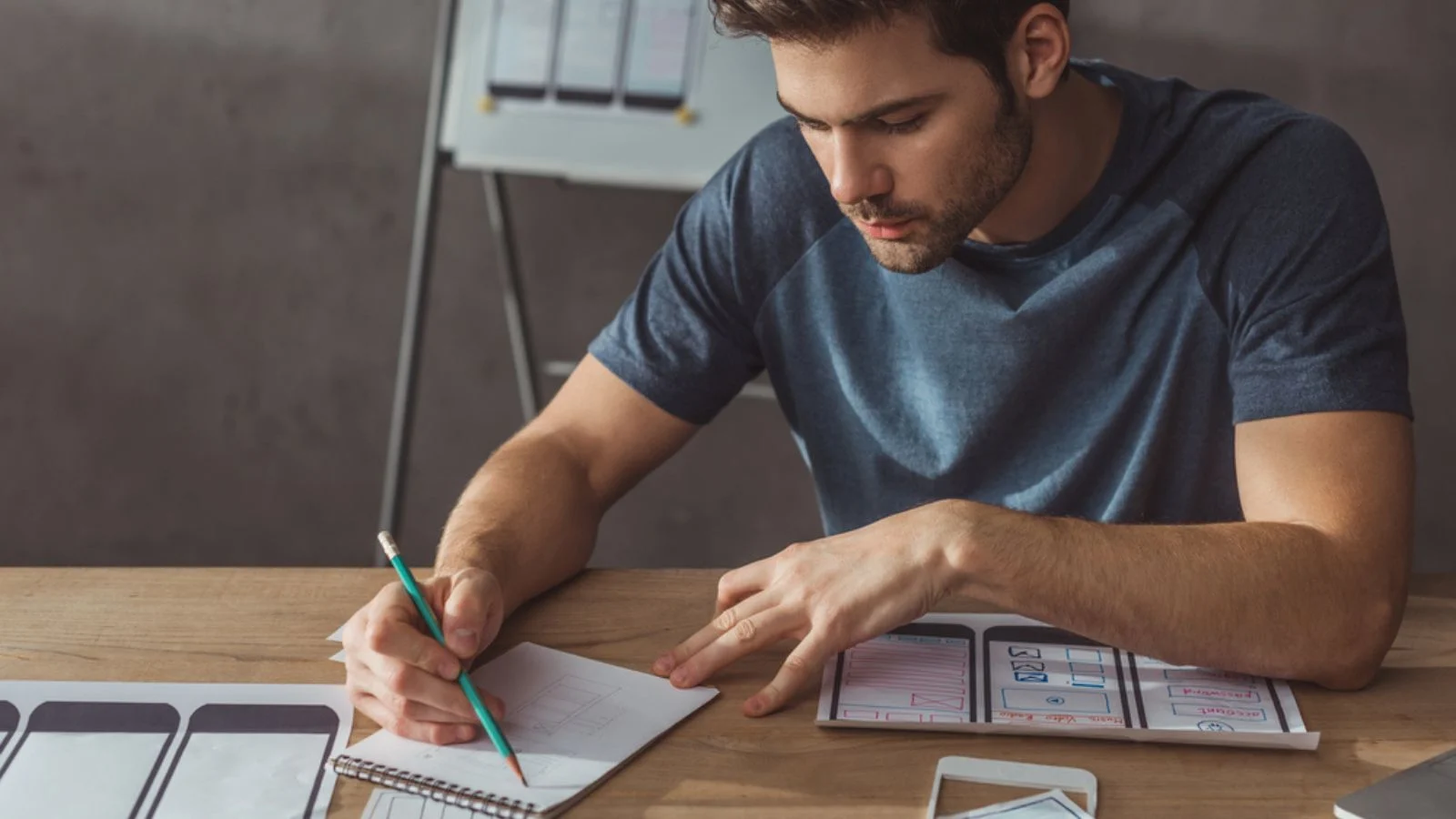 Selective focus of ux designer creative sketches with mobile web template on table