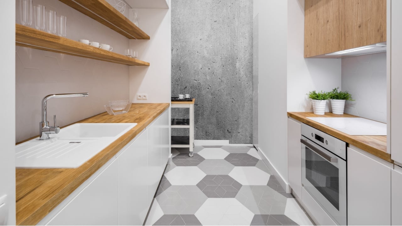 Small, functional kitchen with wooden countertop and hexagonal floor tiles