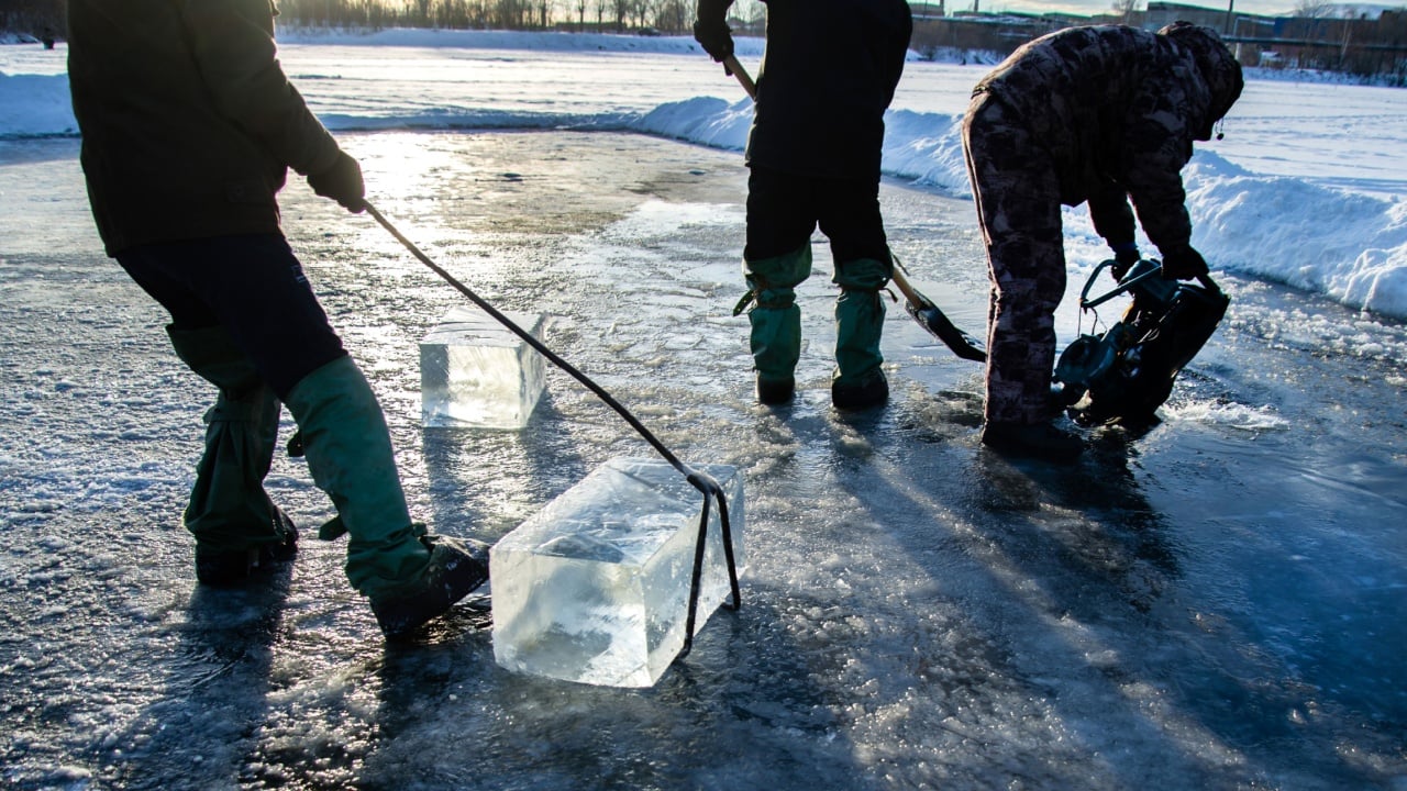 Workers mine large cubes of natural river ice. Ice block. A large block of sawed-up river ice.