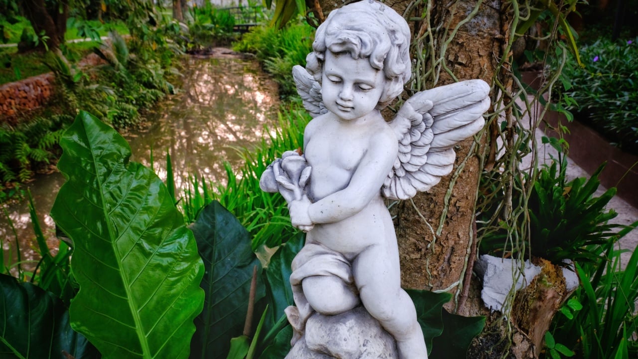 Little cupid statue in the garden.