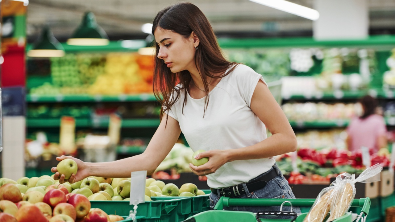 Vegetables and fruits. Female shopper in casual clothes in market looking for products.