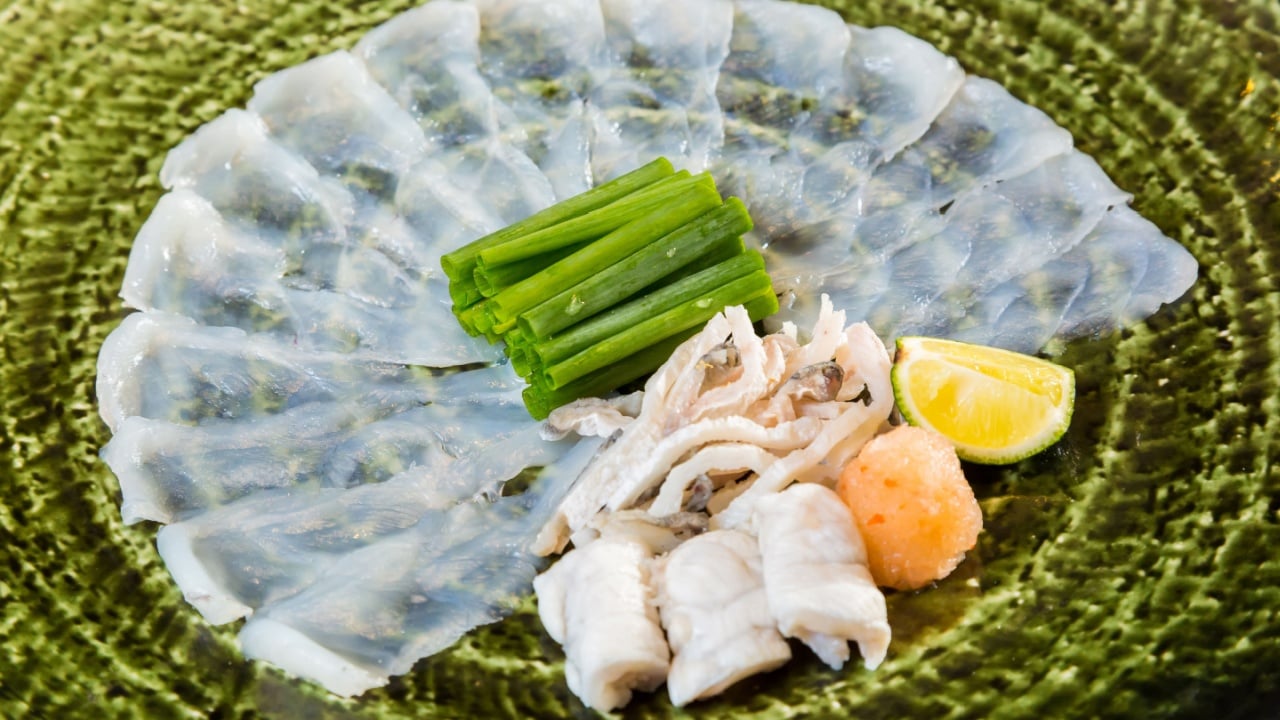 Fugu sashimi and fugu's entrails are in the green plate