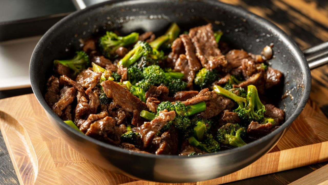 Beef with broccoli vegetables cooking roasting in steel pan.