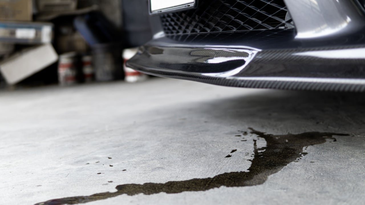 Engine oil stains of car Leak under the car when the car is park In the garage service floor photo concept for check and maintenance