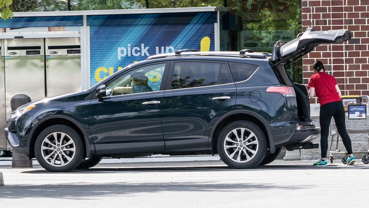 Berks County, Pennsylvania, USA - May 19, 2020: Employee puts groceries in customers car at Weis Markets curb side pick-up.