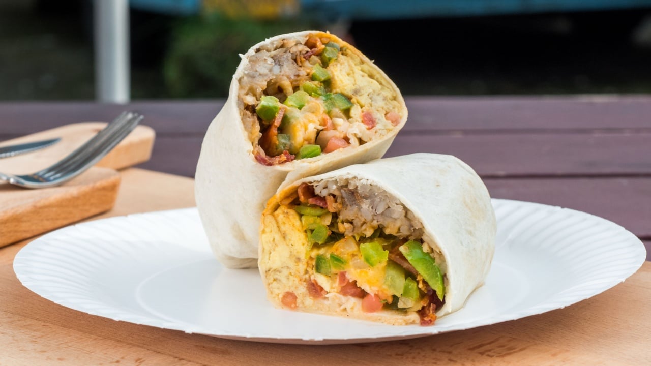 Breakfast burrito made with eggs, bacon, cheese, and bell peppers. Mexican inspired food for the morning.