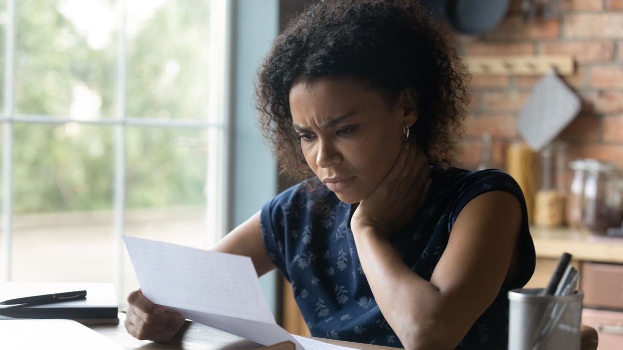 Close-up hands of unrecognizable woman work at home in the kitchen with financial papers, counting on a calculator, paying bills, planning a budget to find a way to save money. Independent accounting