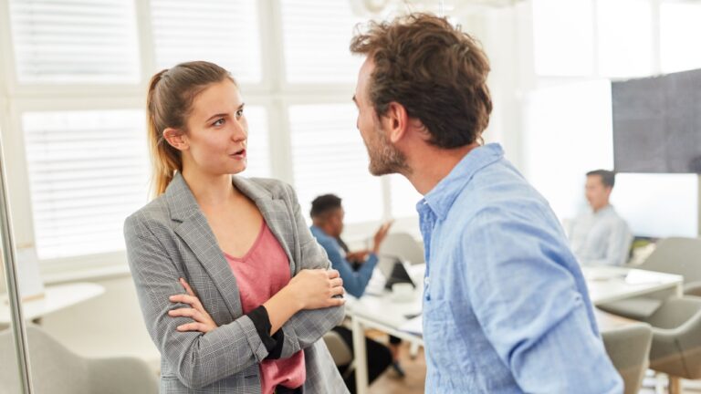 Two business people in dialogue or having relaxed small talk in the office