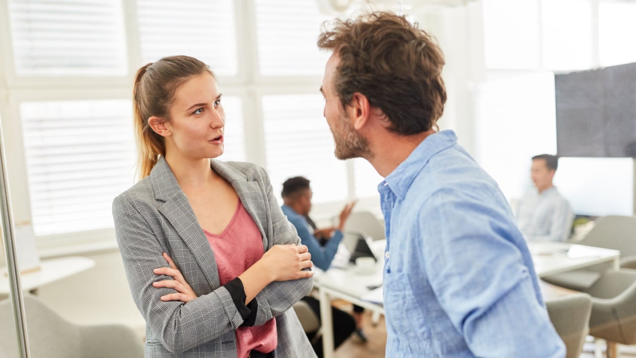 Two business people in dialogue or having relaxed small talk in the office