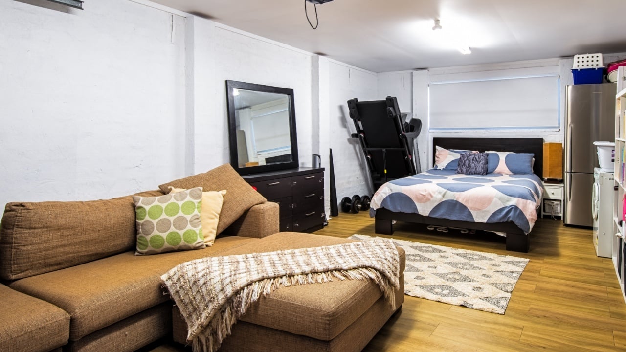 Turramurra, Sydney, Australia - Jun 14 2020: Garage converted to spare room in a suburban home filled with lounge, double bed, tred mill, storage and washing machine.