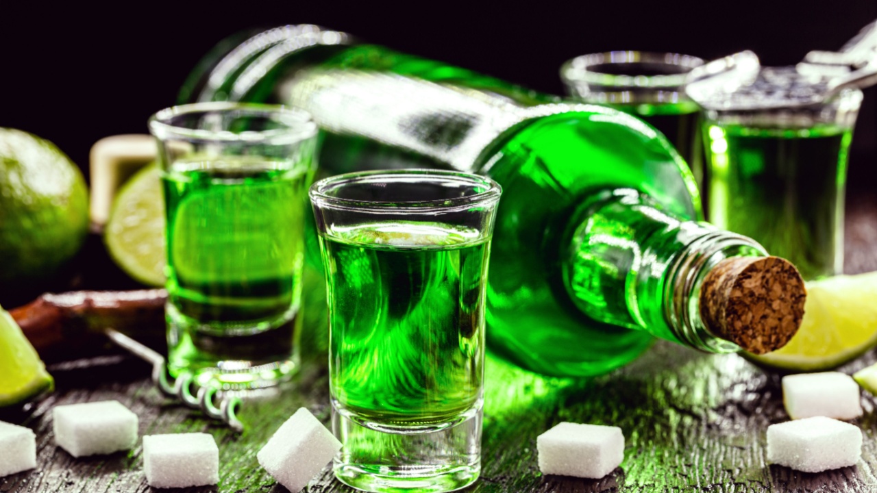 doses of absinthe with sugar cubes. Absinthe bottle, green distilled drink