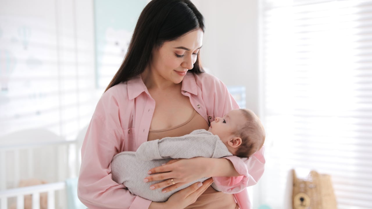 Young woman with her cute baby at home
