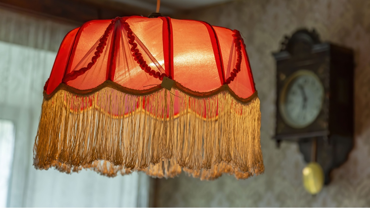 Vintage lampshade made of red fabric with fringes as an element of the decor of the interior of the room