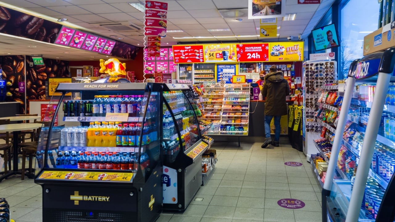 Turku, Finland - December 24, 2021: Horizontal View of Shell Gas Station Convenience Store Cashier and Customer.