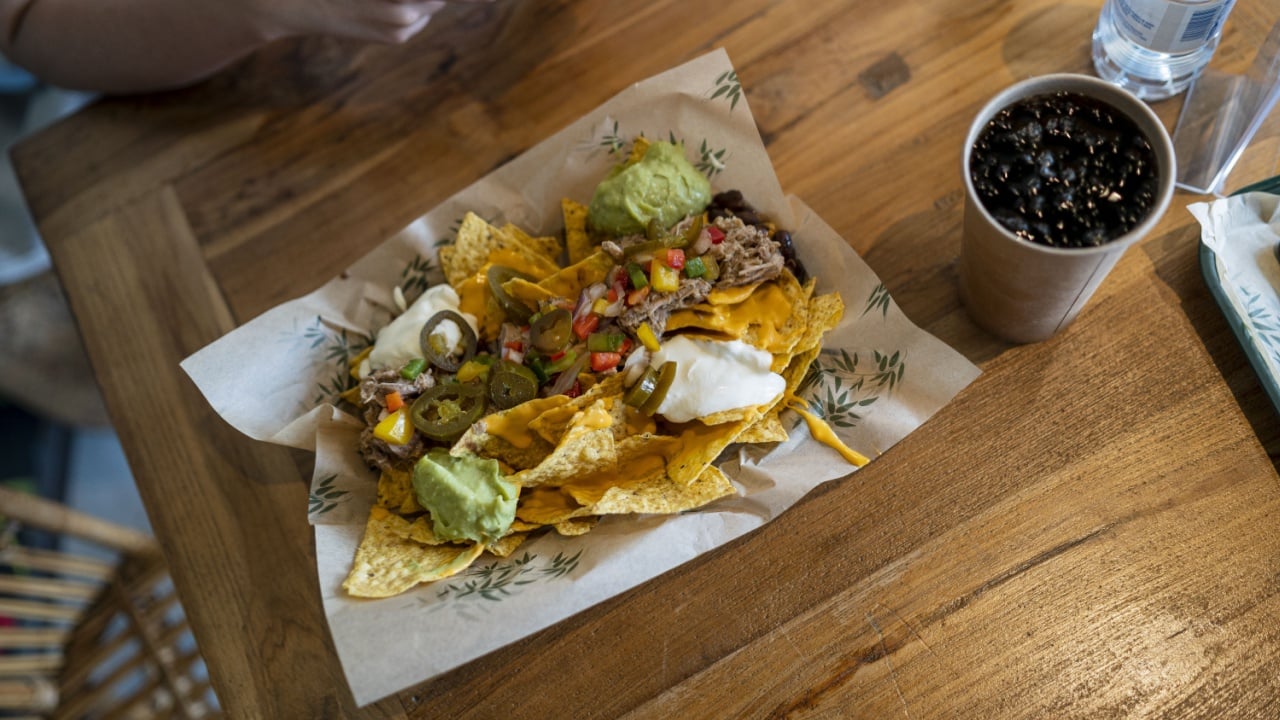 A closeup of fast food with meat and French fries on a paper