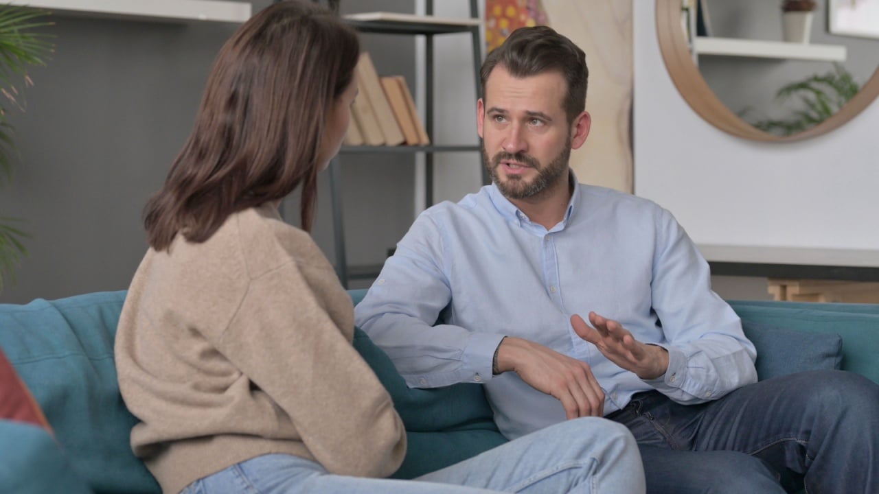 Couple having Argument While Sitting on Sofa