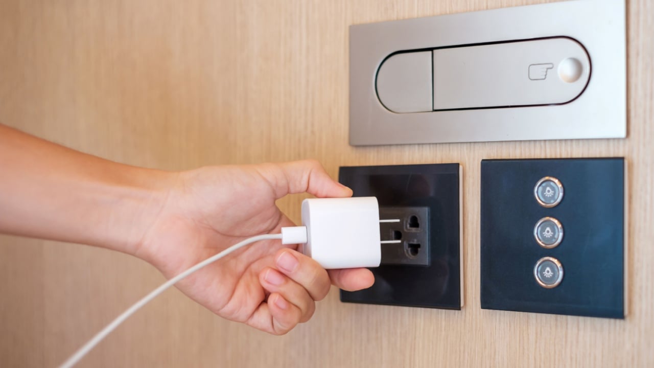 Closeup finger unplugging or plugging of electricity device at home. Energy Saving, power, electrical