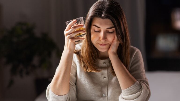 drunk woman or female drinking alcohol whiskey at home