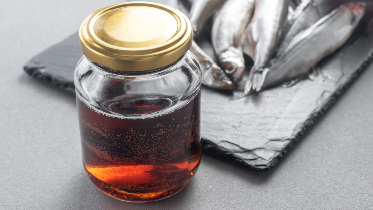 Garum is a fermented fish sauce. Prepared by fermentation from fish, salted garum sauce in a bottle on a gray background. Garum fish sauce made from anchovies on the grey background