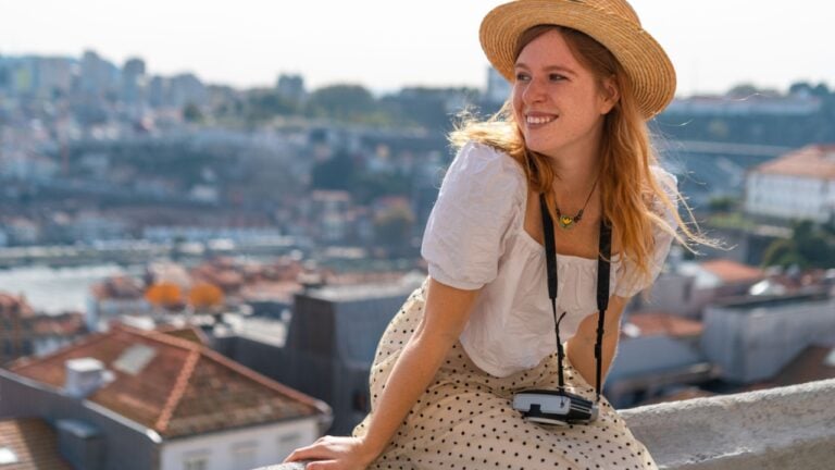 Happy Young tourist woman enjoying a vacation in Europe against the view of the cityscape of old european town