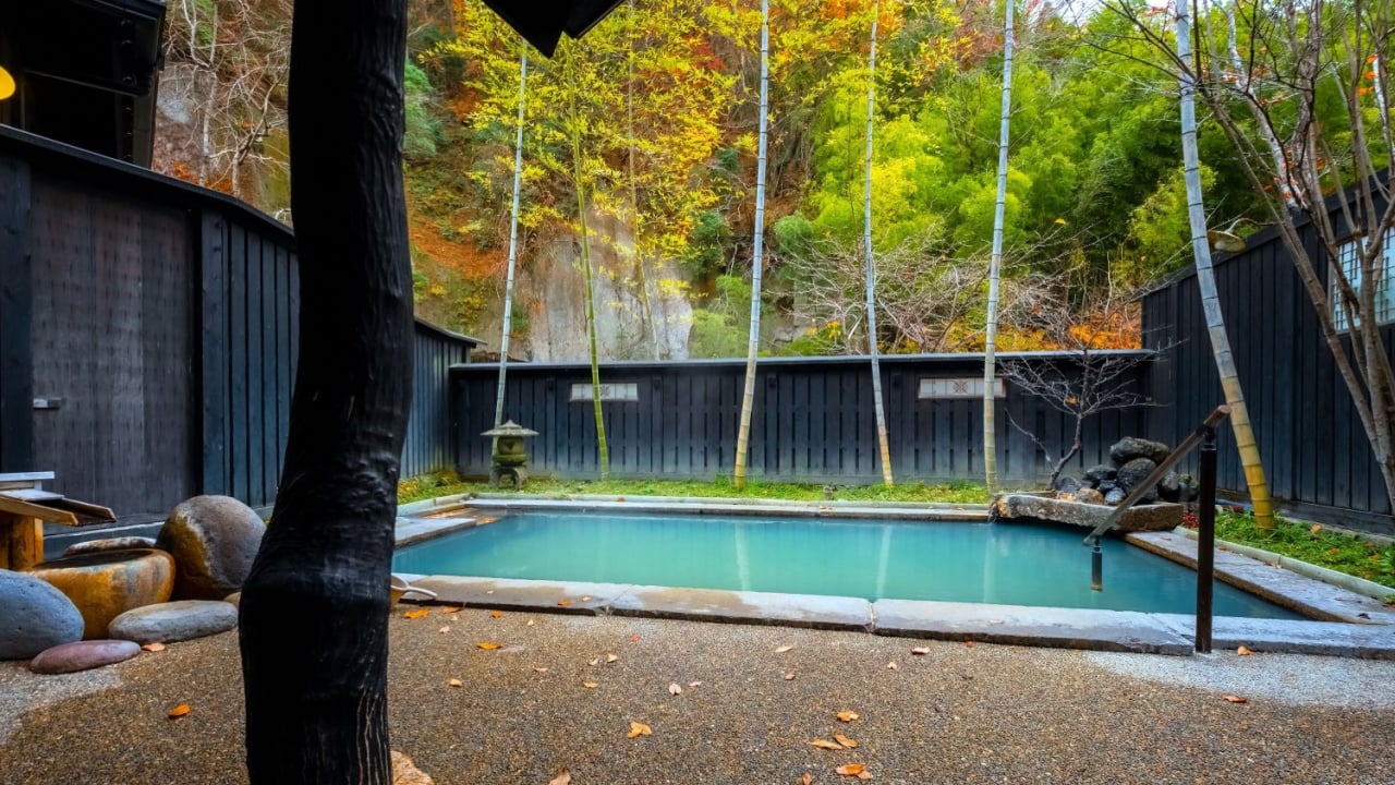 Kumamoto, Japan - Nov 22 2022: An open-air public bath surrounded by natural environment at Kurokawa Onsen, one of Japan's most attractive hot spring towns.