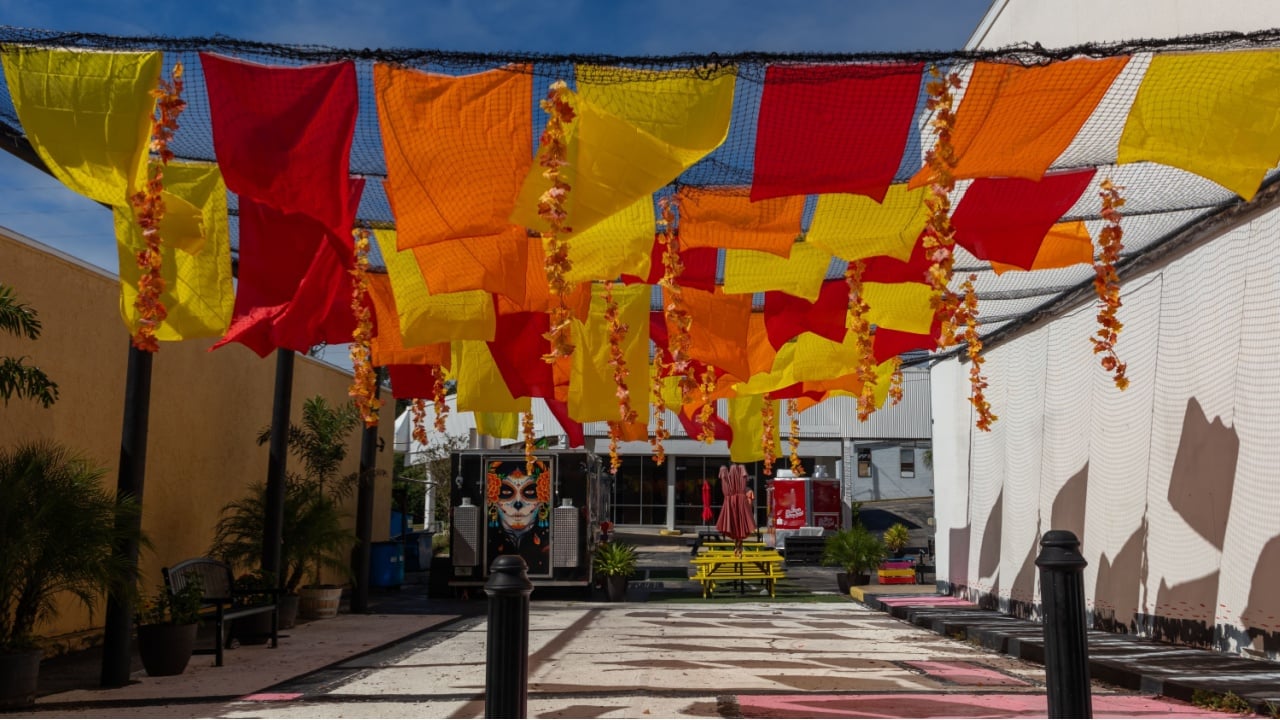 Haines City, Florida, USA 10-25-23. Historic downtown food truck area with bright blowing flags hanging across courtyard