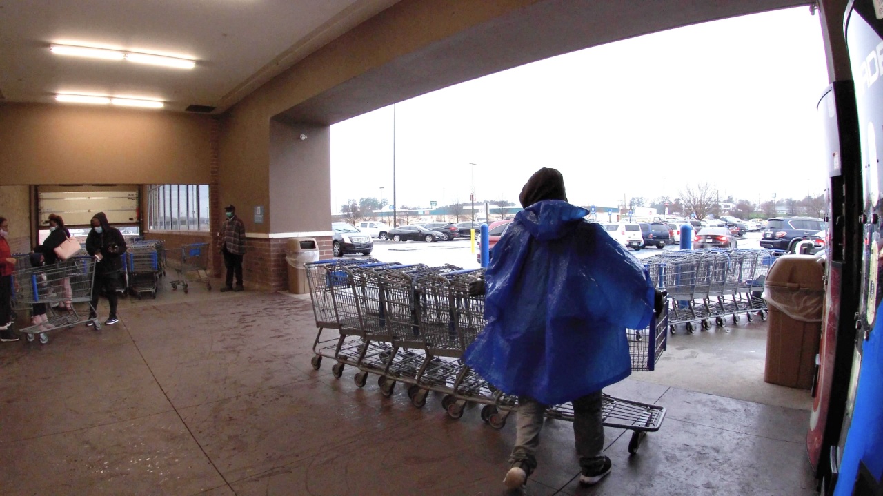 Augusta, Ga USA - 01 21 22: Walmart super center worker gathering carts