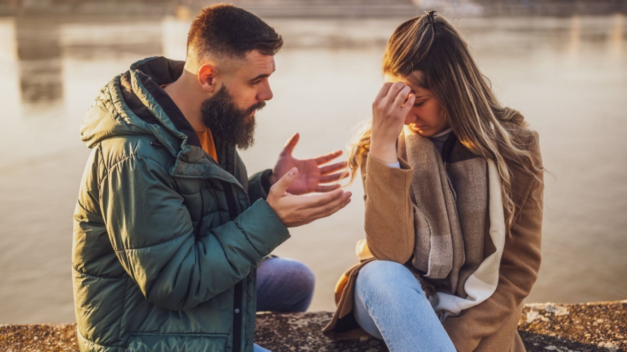 Couple having conflict and they are arguing while sitting outdoor.