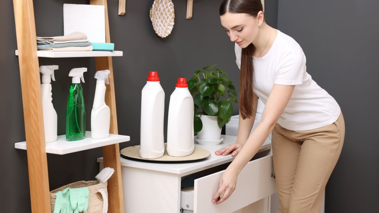 Beautiful woman opening drawer in laundry room