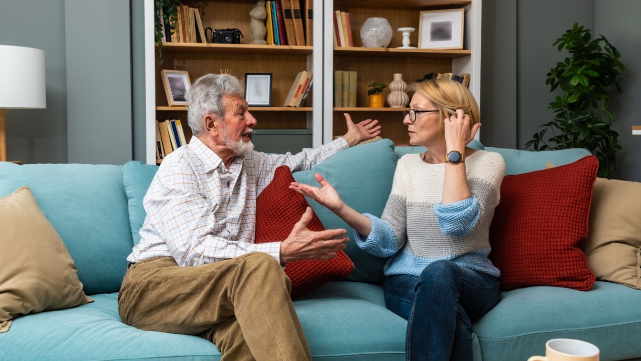 Marital problems and issues. Senior couple sitting at home and argue. Man offend woman. Husband and wife trying to find solution for their relationship and marriage. Quarrel and crisis.