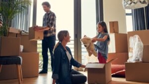 Teddy bear, boxes and parents with child in new home bonding together for family time. Conversation, mortgage and girl kid with mom and dad for fun and unpacking cardboard package for moving to house