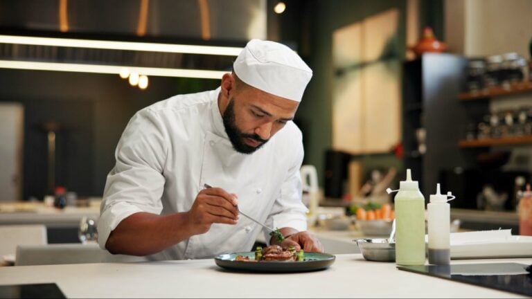 Man, chef and serious with food in kitchen at restaurant for fine dining, meal and creativity. Male employee, professional and cooker with pride for culinarily, hospitality and catering service